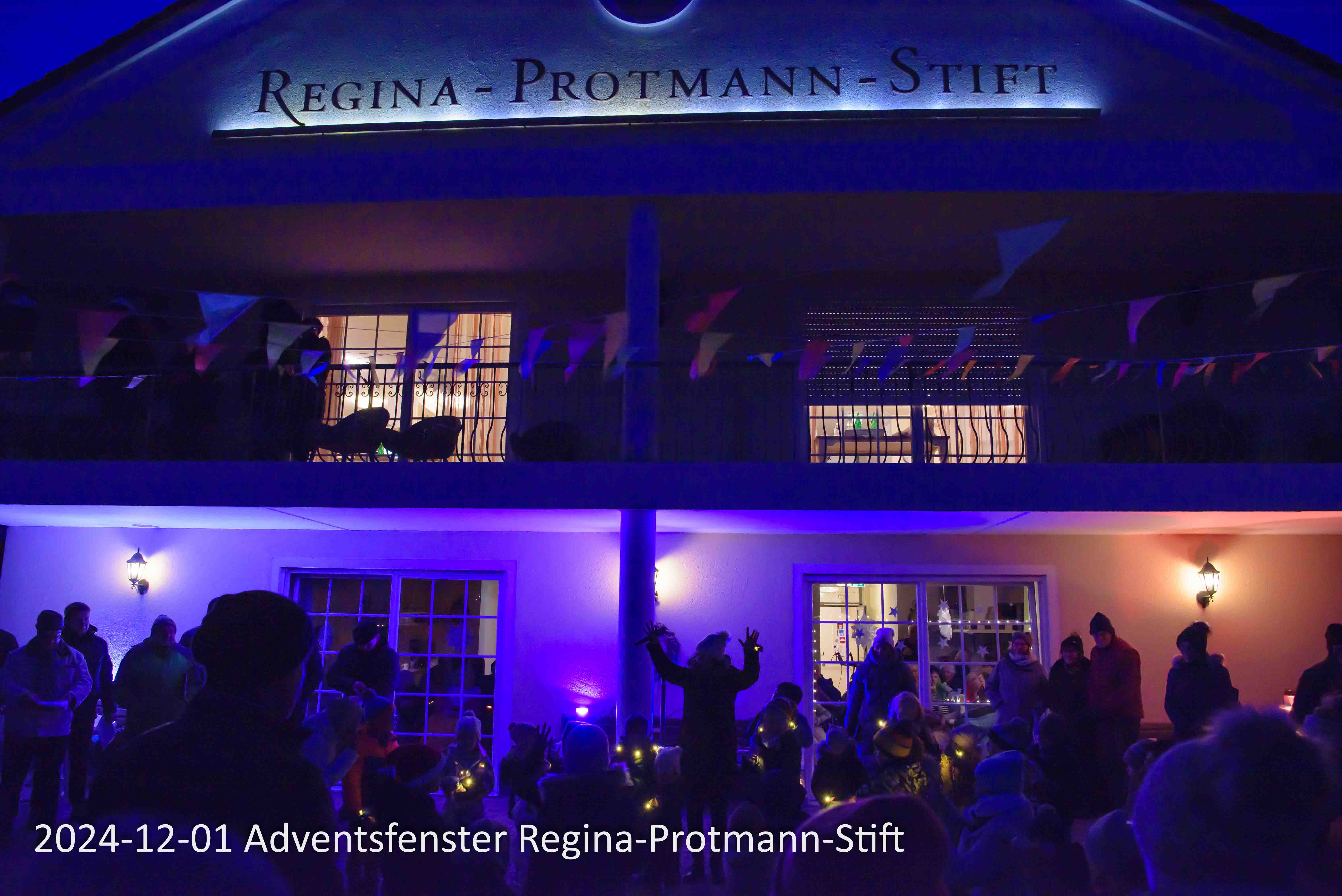 1. Adventsfenster im Pflegeheim Regina-Protmann-Stift in Kelberg. Mit Gesangs, Tanz und Redebeiträgen lokaler Gruppen und anschließenden Heißgetränken. Im Sommergarten des Pflegewohnheimes gemeinsam mit der anwohnenden Bevölkerung.